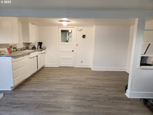 kitchen with sink, white cabinets, and light wood-type flooring