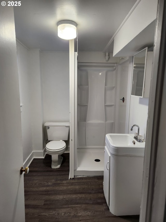 bathroom featuring toilet, a shower, crown molding, wood-type flooring, and vanity