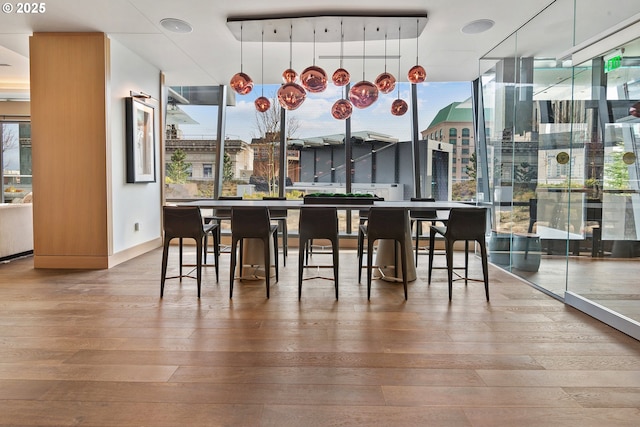 550 SW 10th Ave Unit 2306, Portland, OR 97205 - dining room featuring baseboards, expansive windows, and hardwood / wood-style flooring