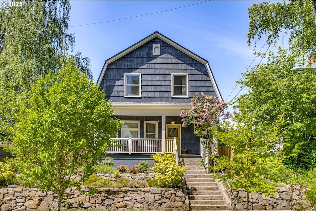 2229 NE 8th Ave, Portland, OR 97212 - colonial inspired home featuring a gambrel roof, covered porch, and stairway