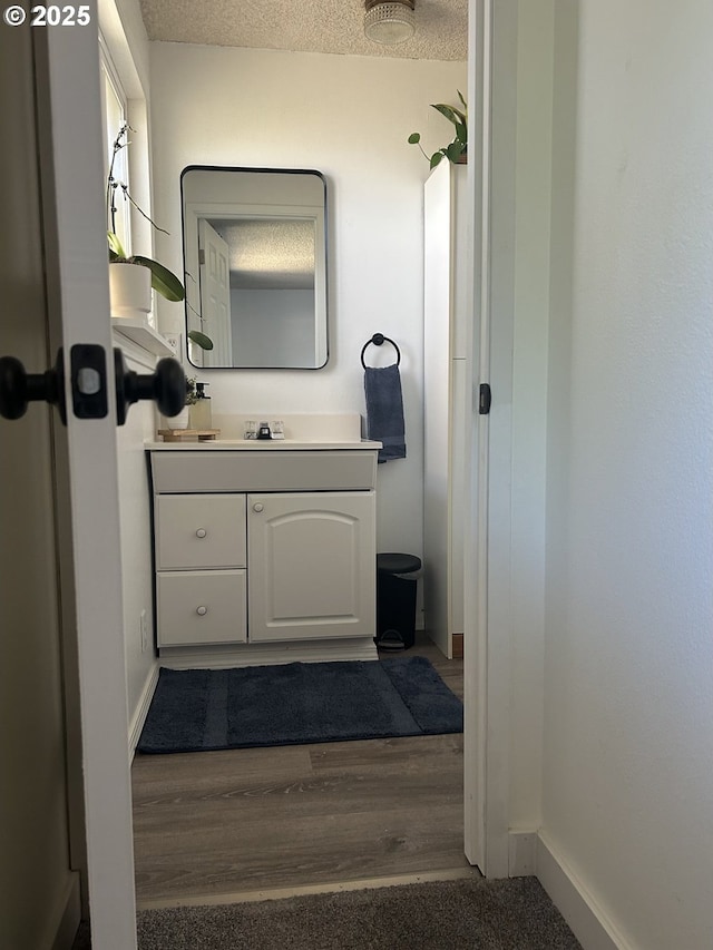 715 N 16th St, Cottage Grove, OR 97424 - bathroom with vanity, baseboards, wood finished floors, and a textured ceiling