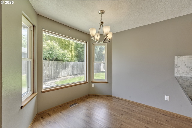 16541 NW Meadow Grass Ct, Beaverton, OR 97006 - empty room with a chandelier, wood finished floors, and a textured ceiling