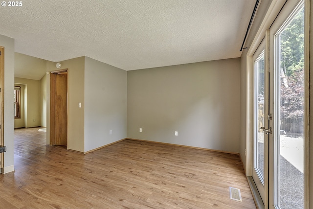 16541 NW Meadow Grass Ct, Beaverton, OR 97006 - empty room featuring light wood-style flooring and a textured ceiling