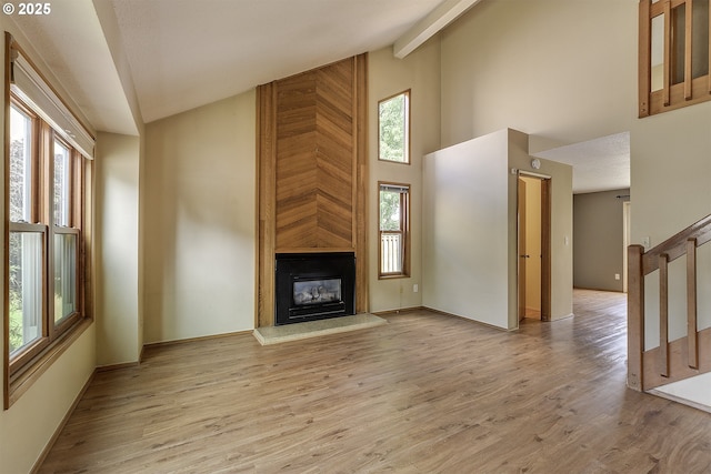 16541 NW Meadow Grass Ct, Beaverton, OR 97006 - unfurnished living room featuring high vaulted ceiling, stairway, a fireplace, and wood finished floors