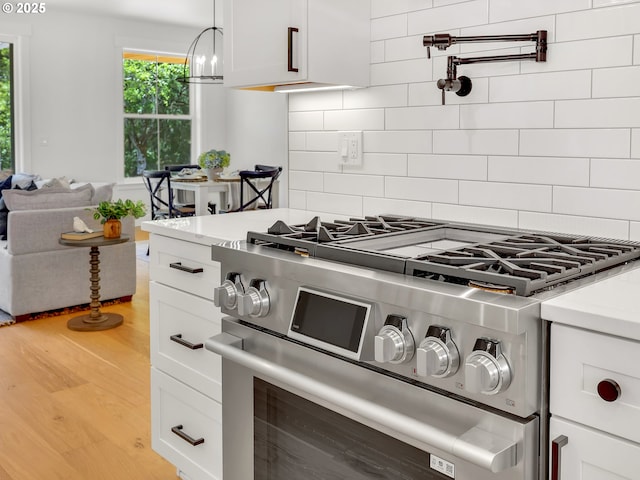90190 Hobie Rd, Warrenton, OR 97146 - kitchen with high end range, light countertops, light wood-style floors, and tasteful backsplash