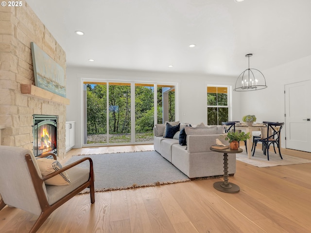 90190 Hobie Rd, Warrenton, OR 97146 - living area with light wood-type flooring, a stone fireplace, a chandelier, and recessed lighting