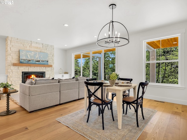 90190 Hobie Rd, Warrenton, OR 97146 - dining area featuring light wood-style flooring, a stone fireplace, a chandelier, and recessed lighting