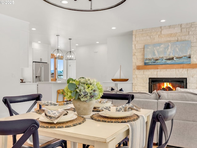 90190 Hobie Rd, Warrenton, OR 97146 - dining space featuring recessed lighting, a stone fireplace, and a chandelier
