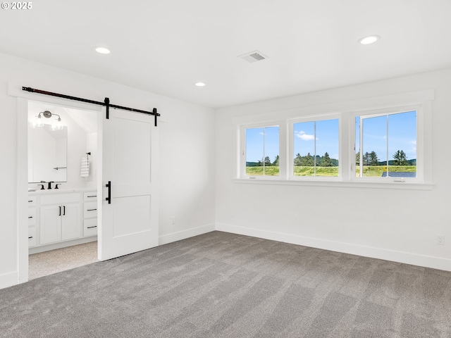 90190 Hobie Rd, Warrenton, OR 97146 - spare room with a barn door, light carpet, and recessed lighting