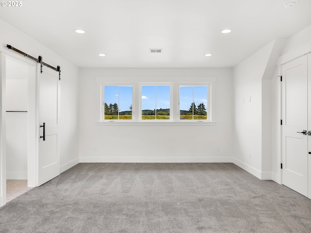 90190 Hobie Rd, Warrenton, OR 97146 - unfurnished bedroom featuring multiple windows, a barn door, carpet floors, and recessed lighting