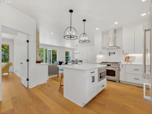 90190 Hobie Rd, Warrenton, OR 97146 - kitchen featuring wall chimney exhaust hood, appliances with stainless steel finishes, light wood-type flooring, and recessed lighting