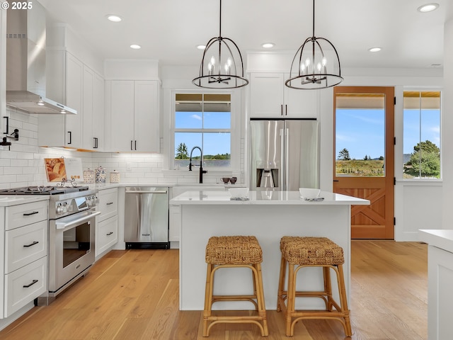 90190 Hobie Rd, Warrenton, OR 97146 - kitchen featuring appliances with stainless steel finishes, wall chimney range hood, a chandelier, light countertops, and tasteful backsplash