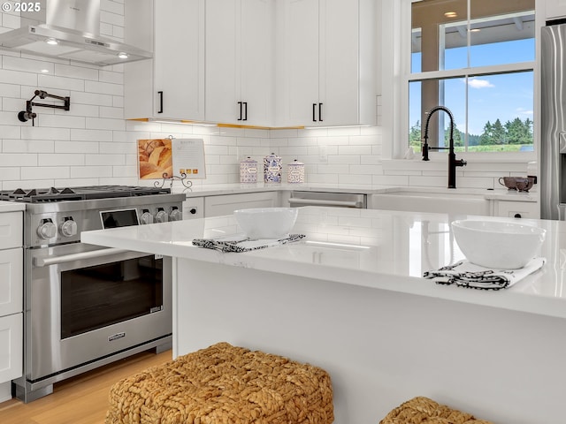 90190 Hobie Rd, Warrenton, OR 97146 - kitchen featuring stainless steel appliances, range hood, tasteful backsplash, and white cabinets