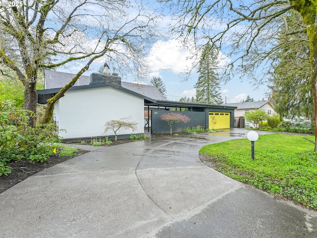 767 NE 152nd Ave, Portland, OR 97230 - view of side of property with a garage, driveway, a chimney, and a lawn