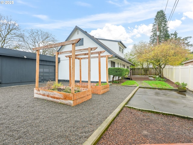 767 NE 152nd Ave, Portland, OR 97230 - back of property with a vegetable garden, a fenced backyard, and a patio area