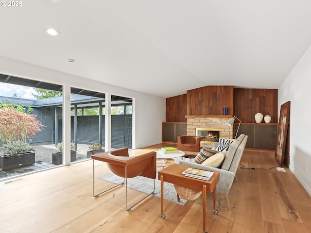 767 NE 152nd Ave, Portland, OR 97230 - living area featuring light wood-style floors, healthy amount of natural light, vaulted ceiling, a glass covered fireplace, and recessed lighting