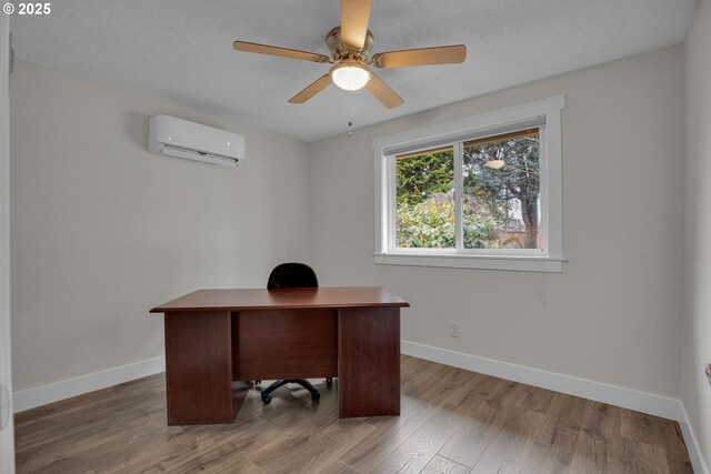 office with a wall unit AC, ceiling fan, baseboards, and wood finished floors