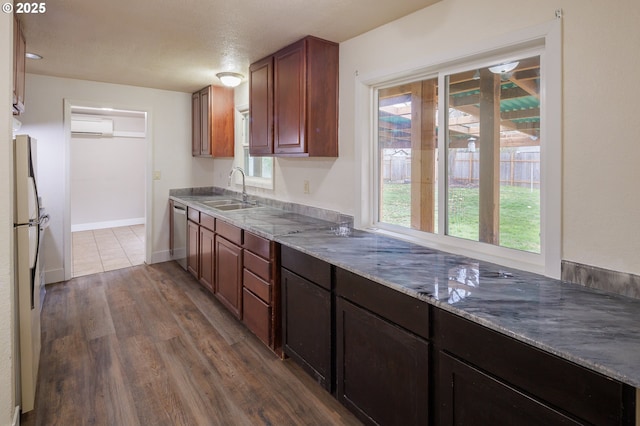 kitchen with hardwood / wood-style floors, sink, dishwasher, a wall mounted air conditioner, and white refrigerator