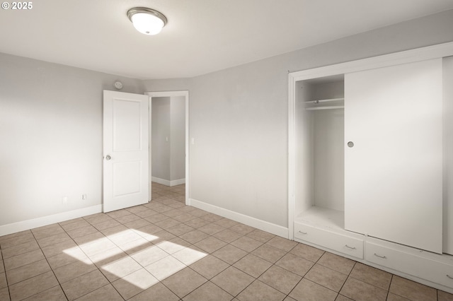 unfurnished bedroom with light tile patterned floors and a closet