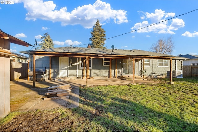 rear view of property featuring a patio and a yard