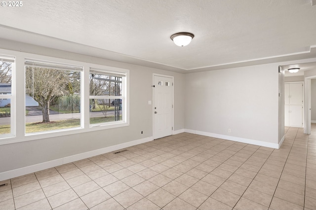 unfurnished room with a textured ceiling and a healthy amount of sunlight