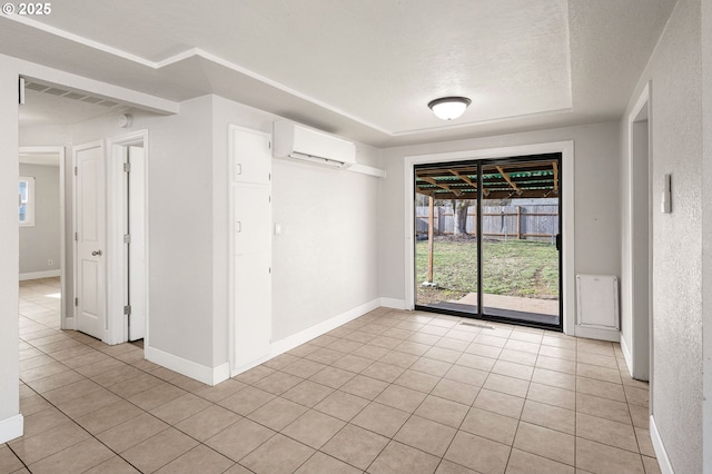 tiled empty room with a wall mounted AC and a textured ceiling