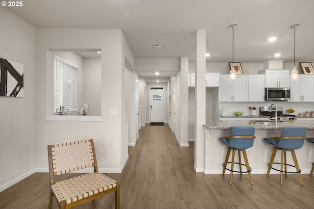 hall with recessed lighting, baseboards, and wood finished floors