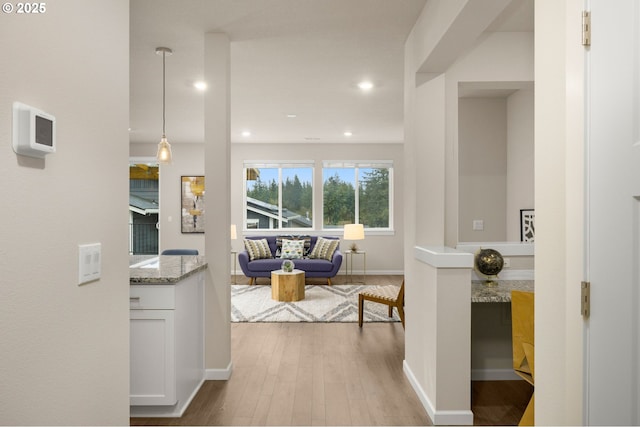 hall with recessed lighting, wood finished floors, and baseboards