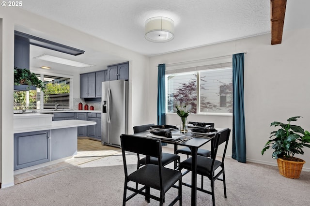 dining area with light carpet and a textured ceiling