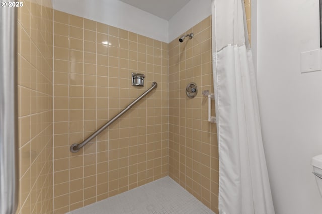 full bathroom featuring toilet and tiled shower