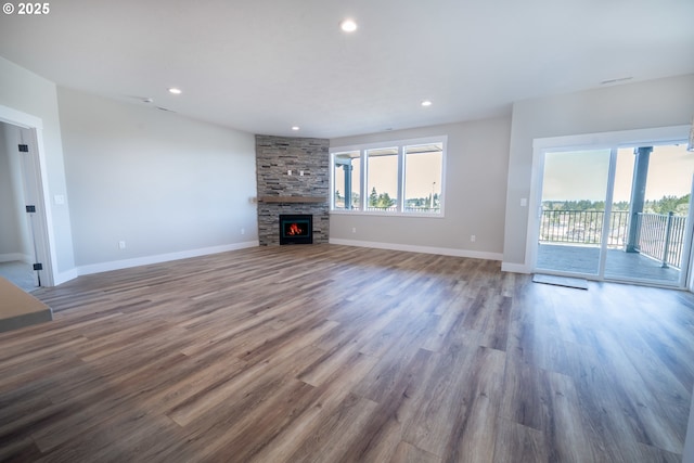 unfurnished living room with hardwood / wood-style floors, a wealth of natural light, and a fireplace