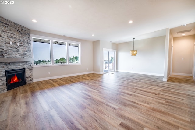 unfurnished living room featuring a fireplace and light hardwood / wood-style floors