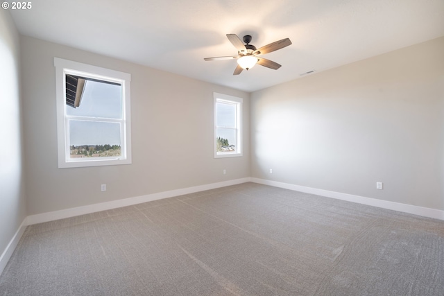 carpeted spare room featuring ceiling fan