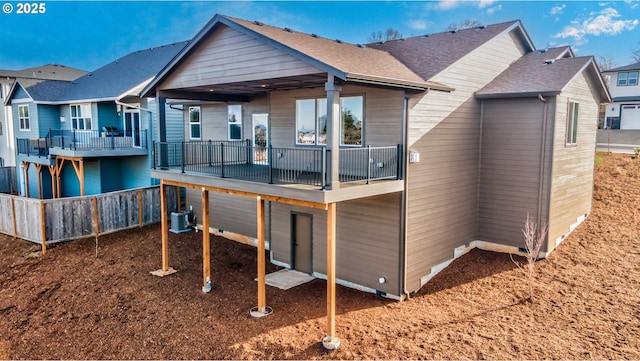 rear view of property featuring a balcony and central AC unit