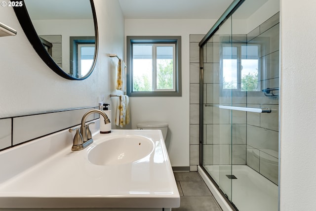 bathroom featuring a shower stall, tile patterned floors, toilet, and vanity