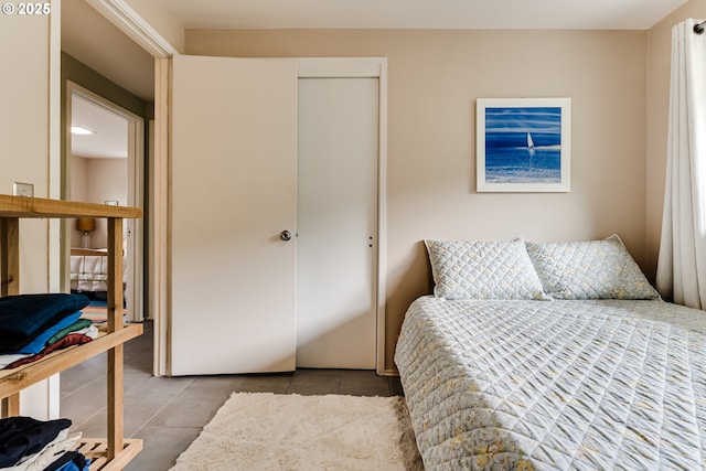 tiled bedroom with a closet