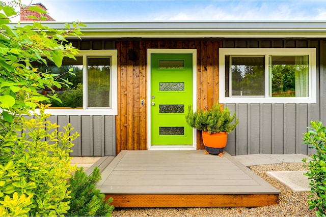 view of exterior entry featuring board and batten siding and covered porch