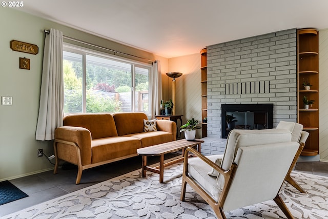 tiled living room with a brick fireplace and baseboards