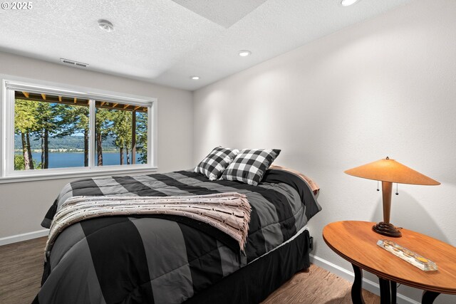 37333 NE Reed Rd, Corbett, OR 97019 - bedroom with wood finished floors, a textured ceiling, recessed lighting, and a water view