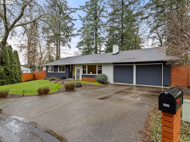 single story home featuring a garage and a front lawn