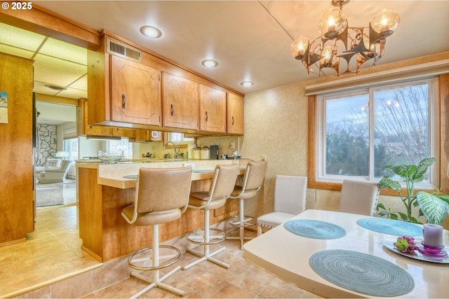 kitchen with visible vents, a kitchen bar, a healthy amount of sunlight, and light countertops