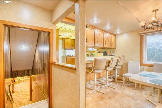 kitchen with light tile patterned floors, visible vents, a chandelier, and a sink