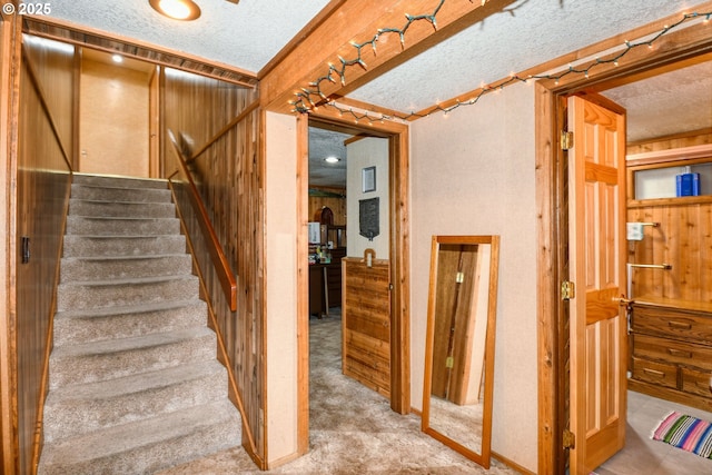 staircase with a textured ceiling and carpet