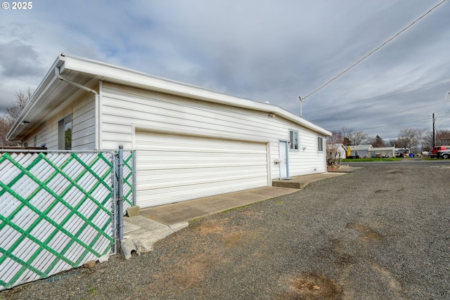 view of side of home with fence and a garage