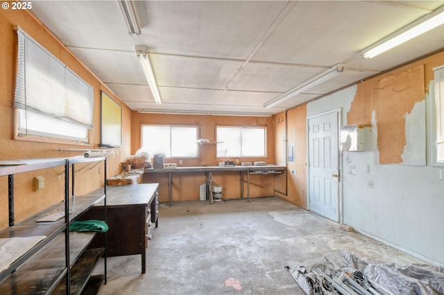 kitchen featuring brown cabinetry, a kitchen bar, and concrete flooring