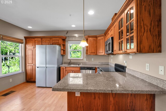 425 SE Shell Ave Unit 4, Depoe Bay, OR 97341 - kitchen with appliances with stainless steel finishes, a sink, glass insert cabinets, a peninsula, and brown cabinets