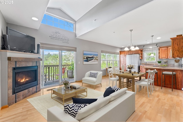 425 SE Shell Ave Unit 4, Depoe Bay, OR 97341 - living room with light wood-type flooring, a fireplace, recessed lighting, vaulted ceiling, and a chandelier