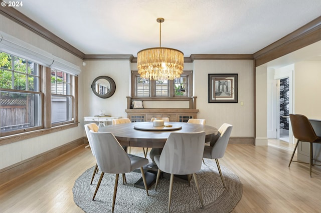 dining area featuring light wood finished floors, baseboards, a chandelier, and crown molding