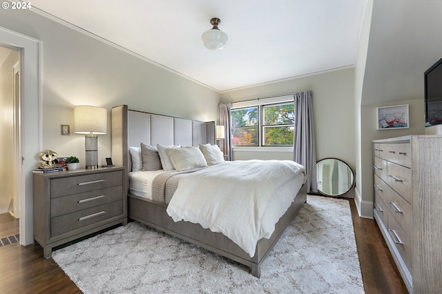 bedroom featuring ornamental molding and dark wood-style flooring