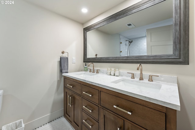 bathroom with visible vents, a sink, baseboards, and double vanity